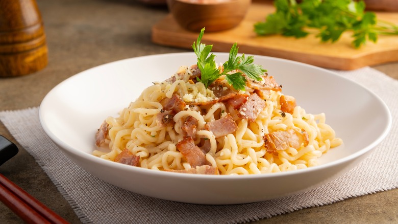 Bowl of ramen carbonara with fresh parsley garnish
