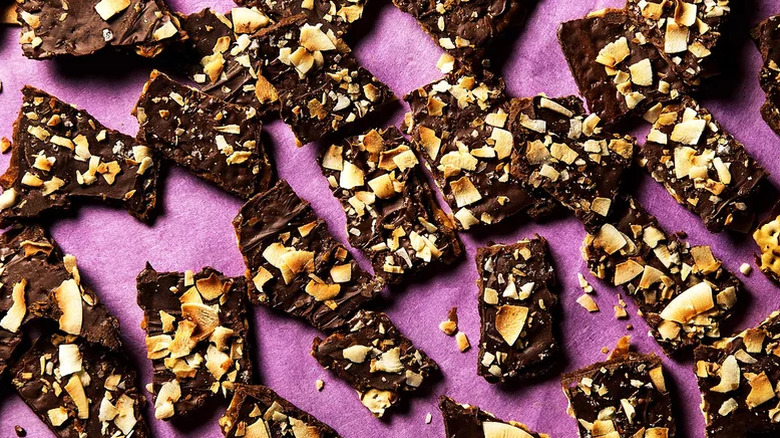 Pieces of chocolate matzo crack on a pink background