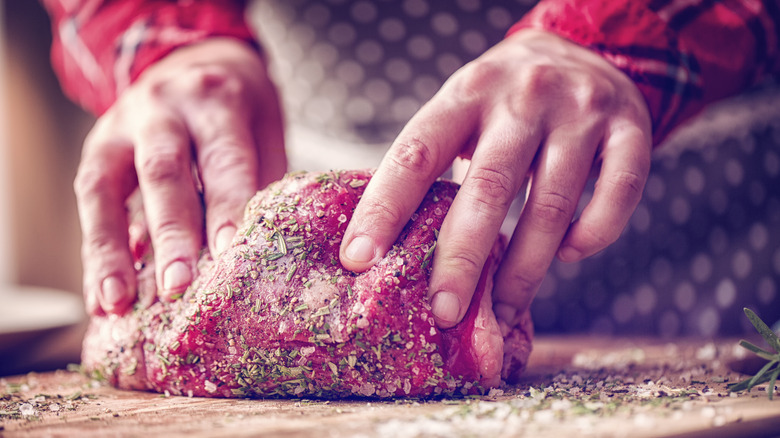 Hands seasoning beef