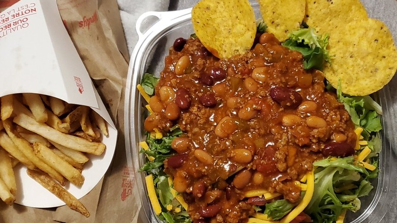 Wendy's taco salad with extra chili beside an order of fries