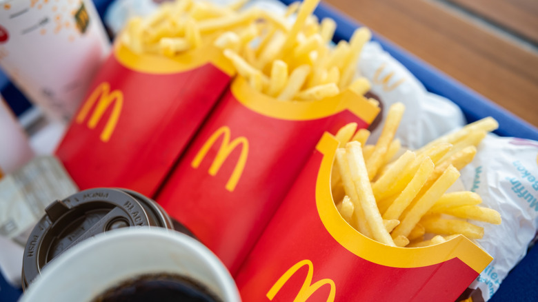 Three portions of McDonald's fries in cardboard cartons on tray
