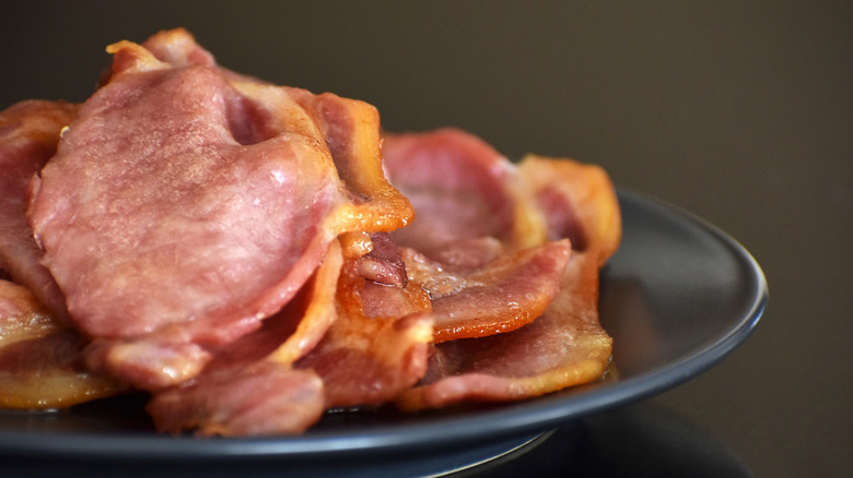 Pile of cooked bacon slices on plate