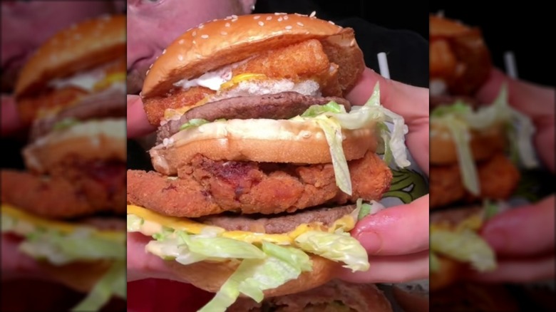 Hands holding McDonald's land, air and sea burger