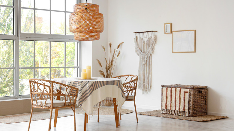 Bright dining room with wooden chairs and table and woven pendant ceiling light