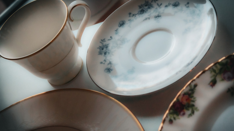 Close-up of mismatched porcelain plates and saucers