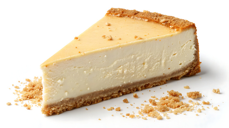 Cheesecake on white background with crumbs