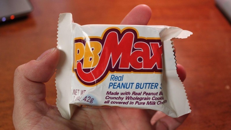 Hand holding PB Max bar over table