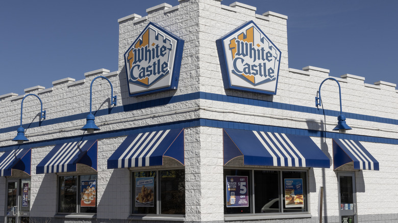 White Castle restaurant against a vivid blue sky, emphasizing the white brick  and blue trim.