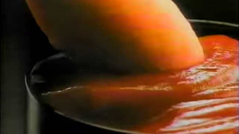 Screenshot from a 1990s McDonald's commercial with Hot Dog McNugget being dipped into ketchup.