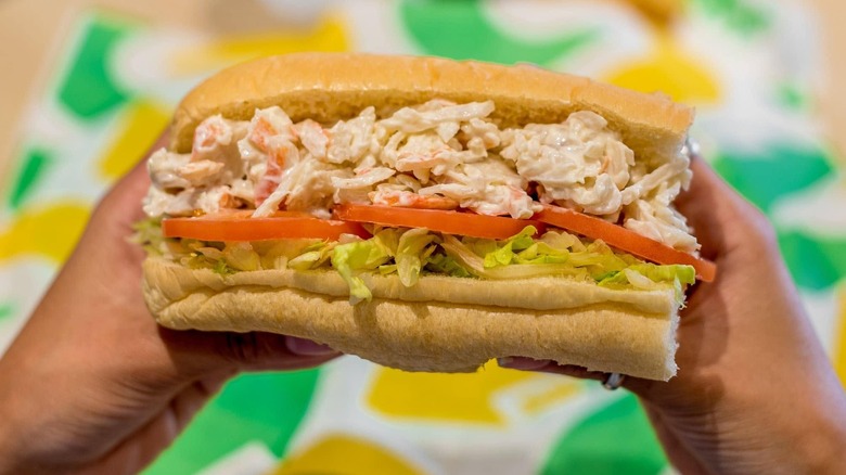 Person holding Subway Seafood Sensation sandwich