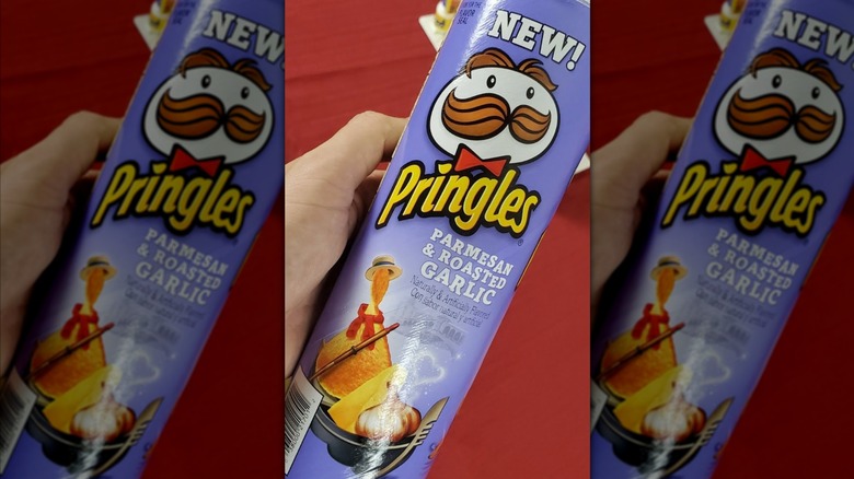 Parmesan & Roasted Garlic being held sideways against red background