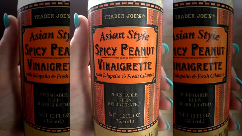 Hand holding bottle of Asian-Style Spicy Peanut Vinaigrette