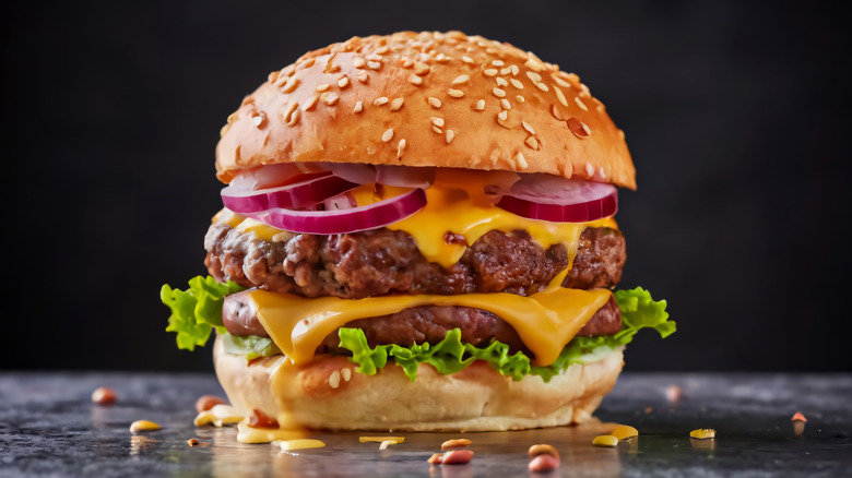 A double cheeseburger stacked with onions and cheese oozing out