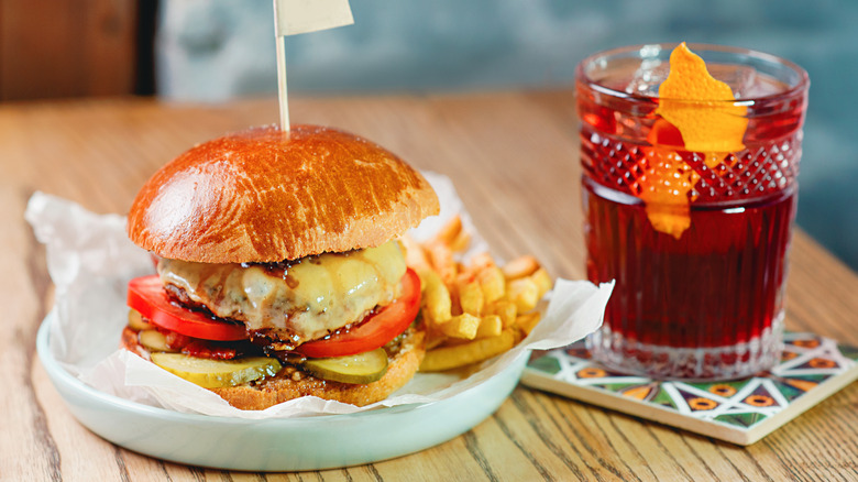 Cheeseburger and Old Fashioned on a wood table