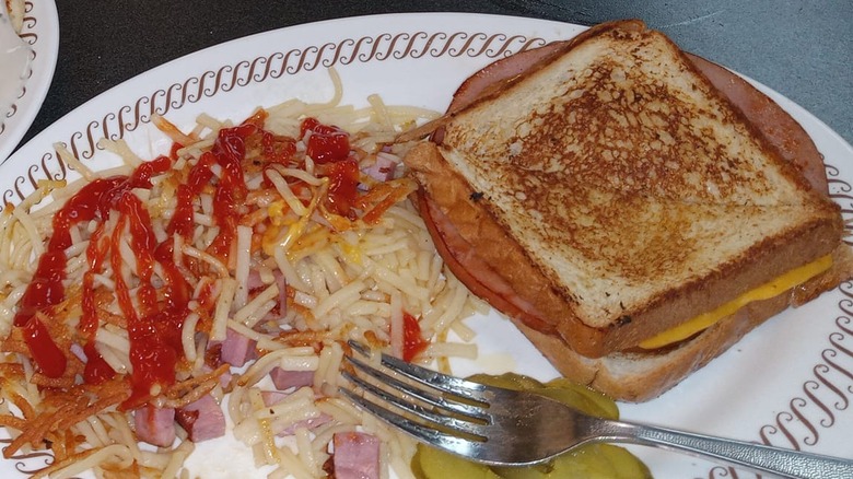 Grilled ham and cheese sandwich on white plate at Waffle House