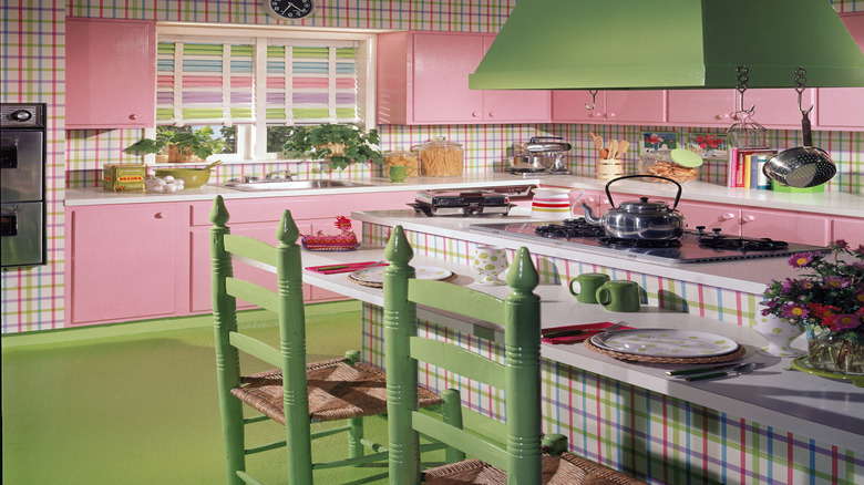 Green range hood against pink cabinetry in a vintage-style kitchen