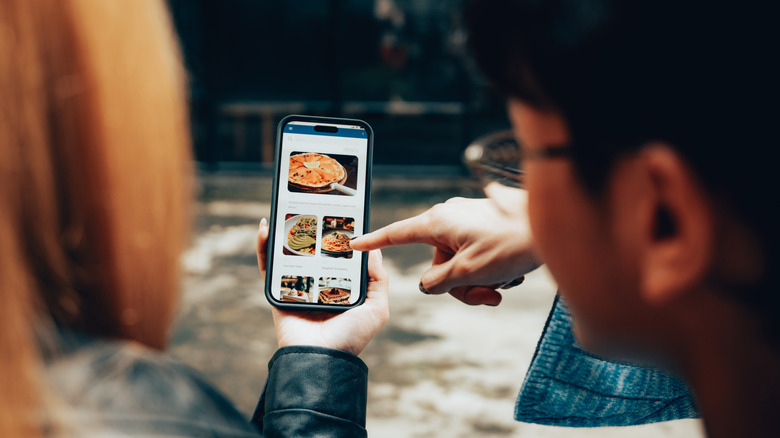 Two people deciding what to order on food delivery app