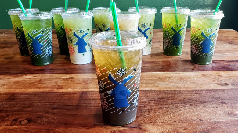 Strawberry matcha lemonade from Dutch Bros on wooden table.
