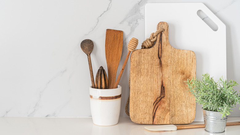 White kitchen countertops with wooden cutting boards and utensils
