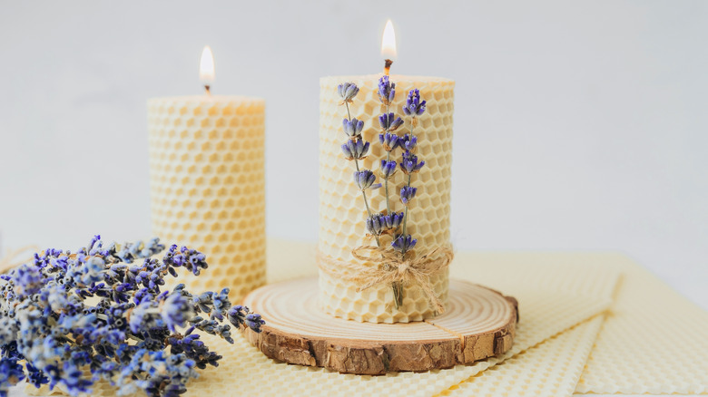 Wax candles arranged next to lavender bunches
