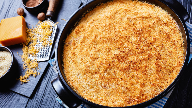 Casserole with crispy breadcrumb topping in black round baking dish
