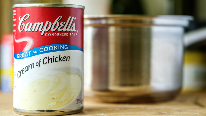 Can of Campbell's Cream of Chicken soup with saucepan in background
