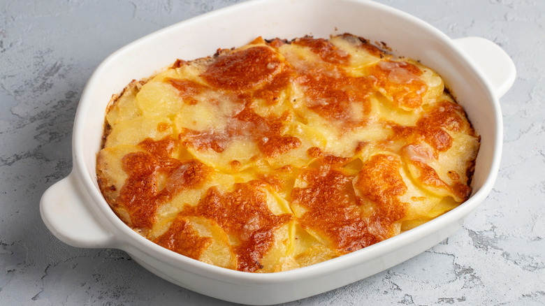 Scalloped potatoes in white casserole dish