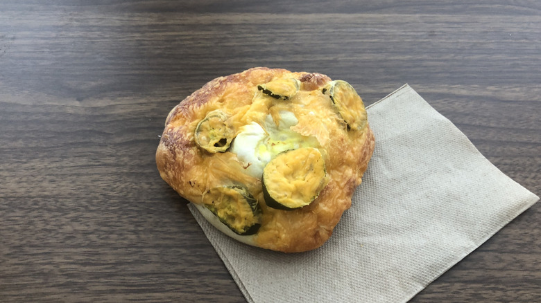Einstein Bros cheddar jalapeno bagel on a napkin.
