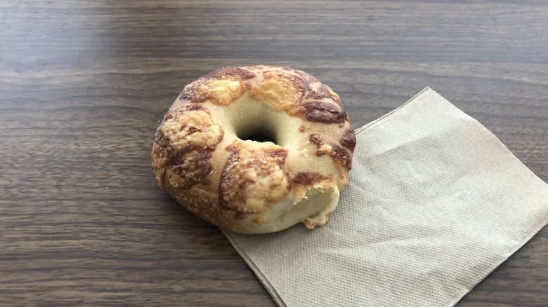 Einstein Bros asiago cheese bagel on a napkin.