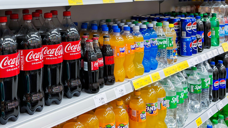 Various types of bottled soda on grocery store shelf