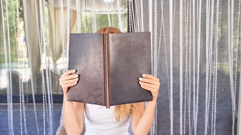 woman hiding behind menu