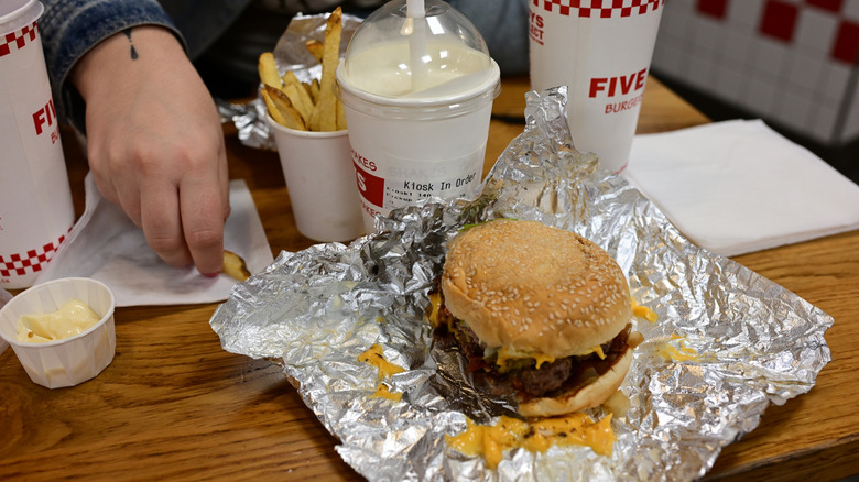 Hamburger meal at a Five Guys restaurant laid out on a table
