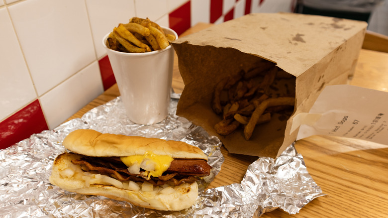 Hot dog and fries on a table inside a Five Guys Restaurant in New York City