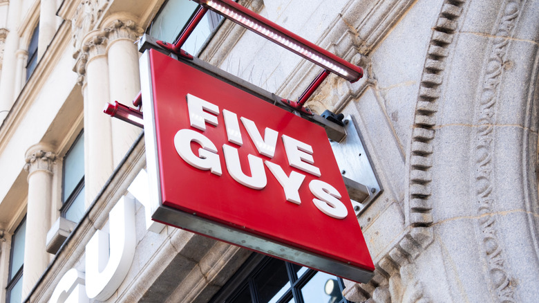 Five Guys sign outside brown building close up