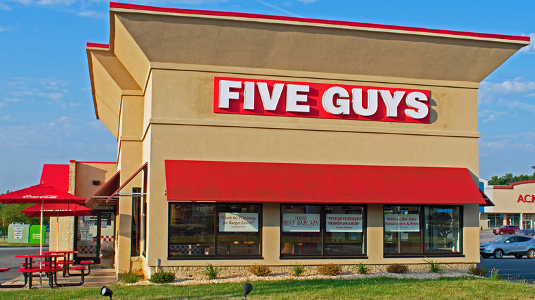 Five Guys restaurant in front of blue sky and green lawn