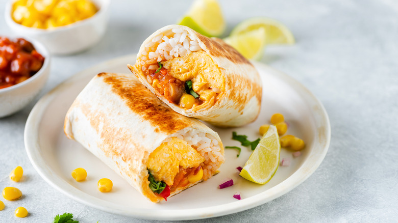 Burrito filled with rice, corn, and egg on plate