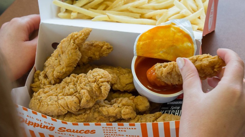Whataburger fried chicken strips with French fries and sauce.