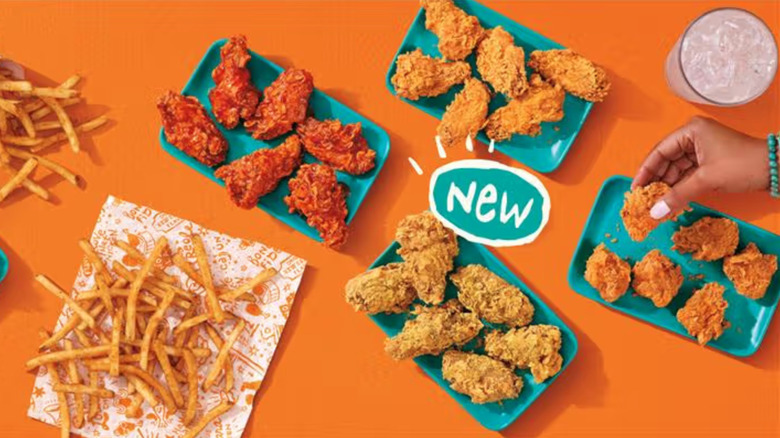 Popeyes wings and fries on blue plates.