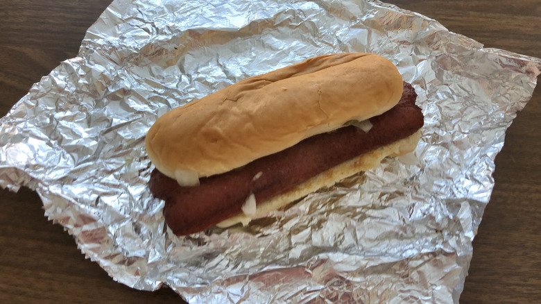 Five Guys flat-top hot dog on aluminum wrapping.
