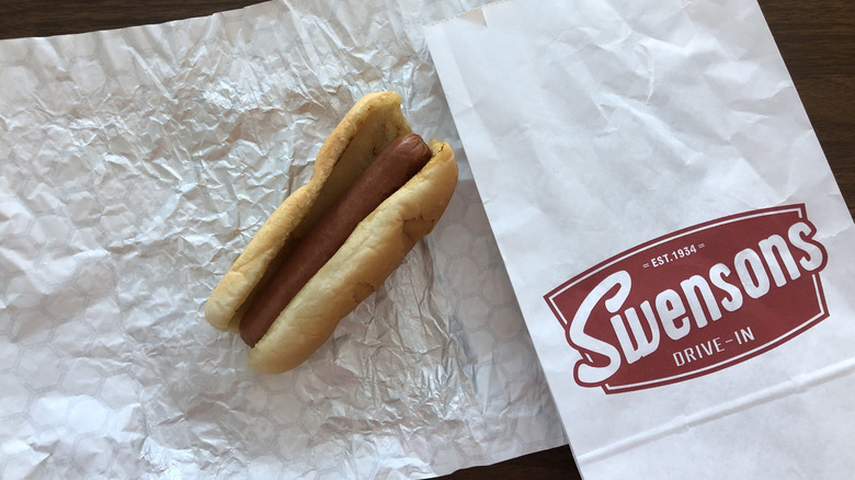Swensons plain hog dog on aluminum wrapper and to-go bag.