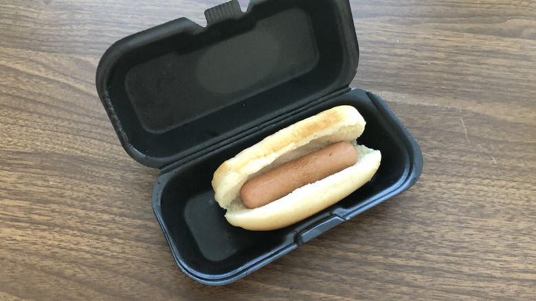 Skyline Chili plain hot dog in black plastic box on wooden table.