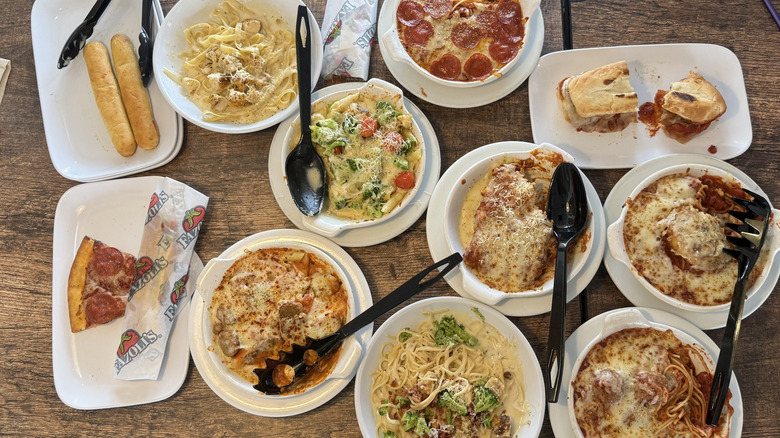 Ten different Fazoli's Italian dishes served on white plates and assembled on a wooden dining table