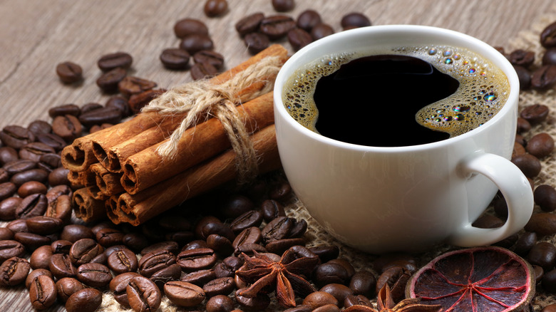 Coffee beans and cup of coffee on a wooden table