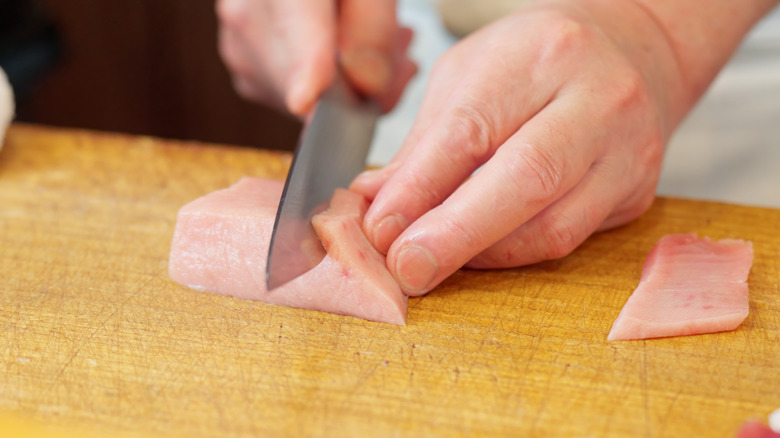 A chef cutting swordfish