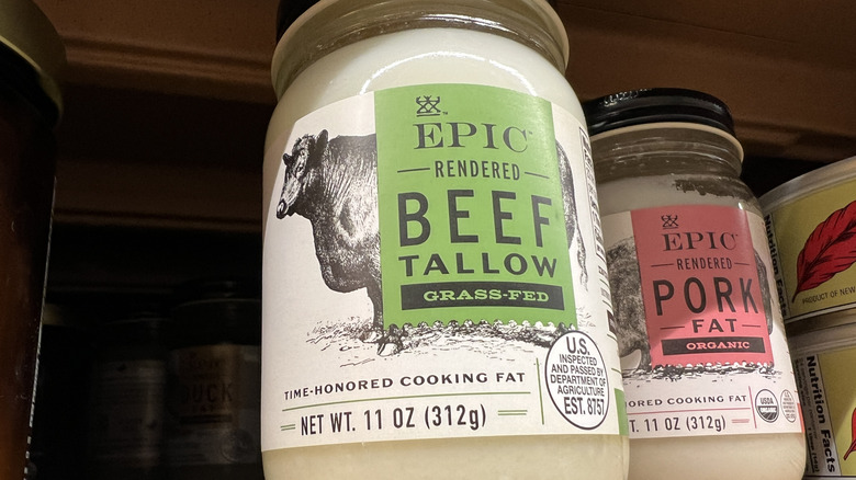 A jar of Epic rendered grass-fed beef tallow on a shelf next to a jar of pork fat