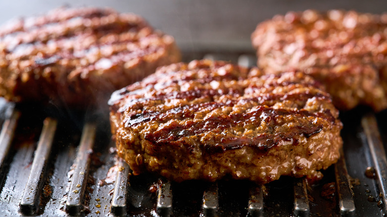 Burger meat patties cooking on a grill