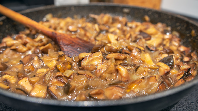 Close up of mushrooms, sliced and fried in a pan