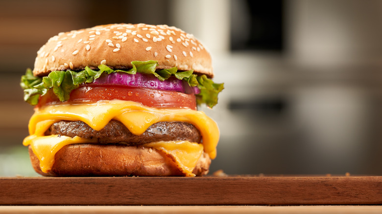 double cheese beef burger with blurred kitchen background