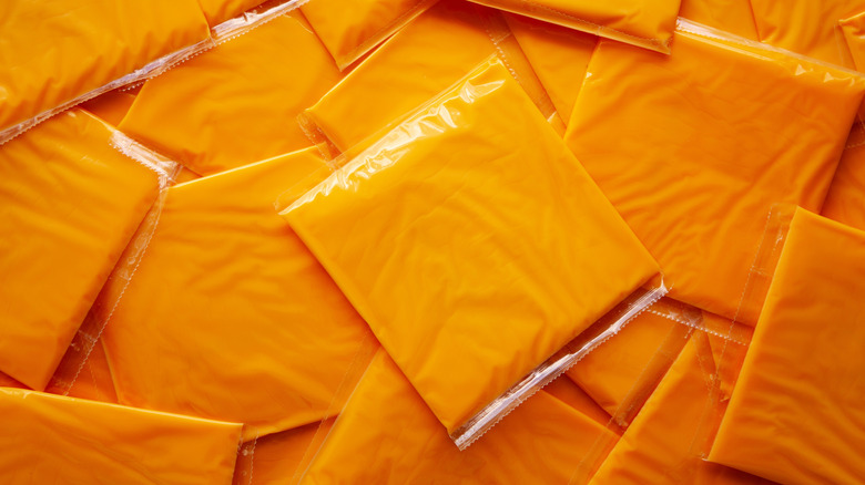 Pile of American Cheese Slices in Wrappers, close up