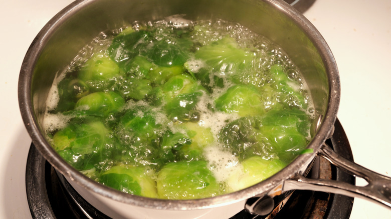 Brussels sprouts boiling in saucepan of water